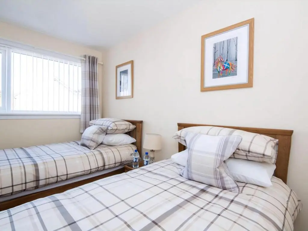 a bedroom with two beds and a window at Raasay in Dornoch