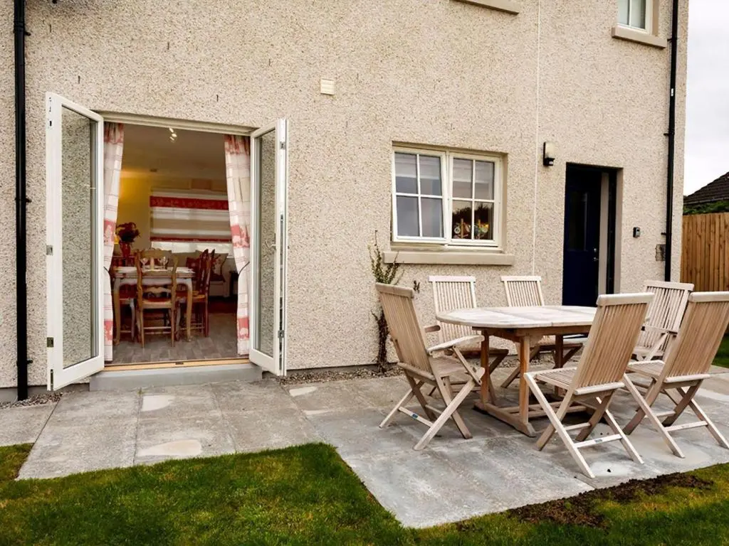 a patio with a table and chairs in front of a house at Grant Crescent in Dornoch