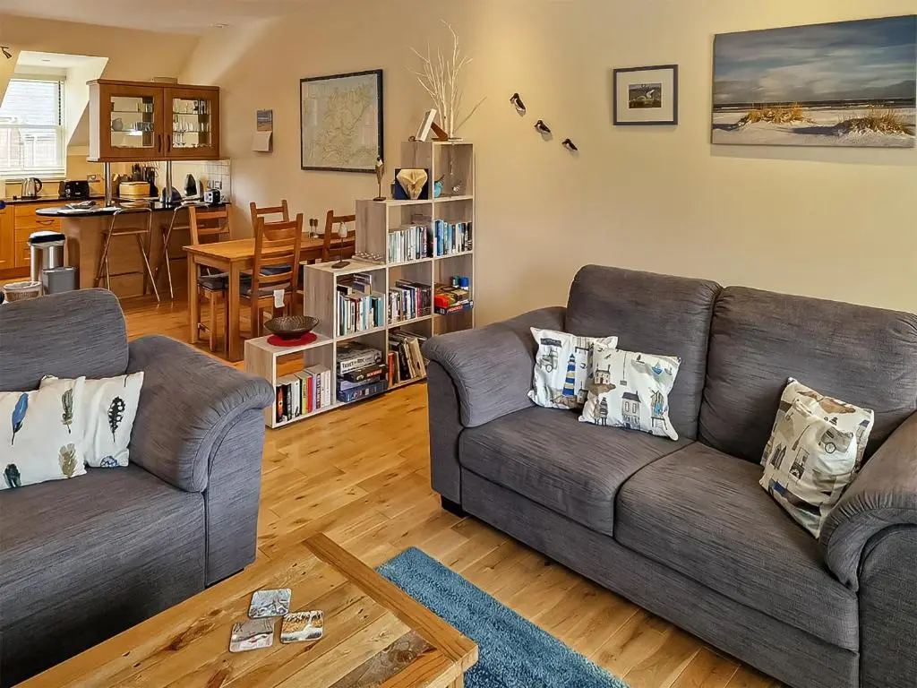 a living room with two couches and a table at Bird's Eye View in Dornoch