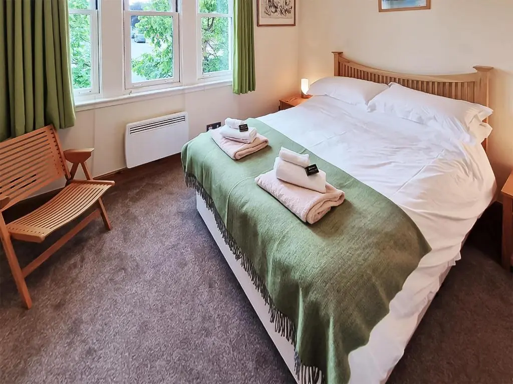 a bedroom with a large bed with towels on it at Bird's Eye View in Dornoch