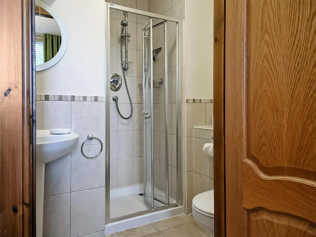 a bathroom with a shower and a toilet and a sink at Bird's Eye View in Dornoch