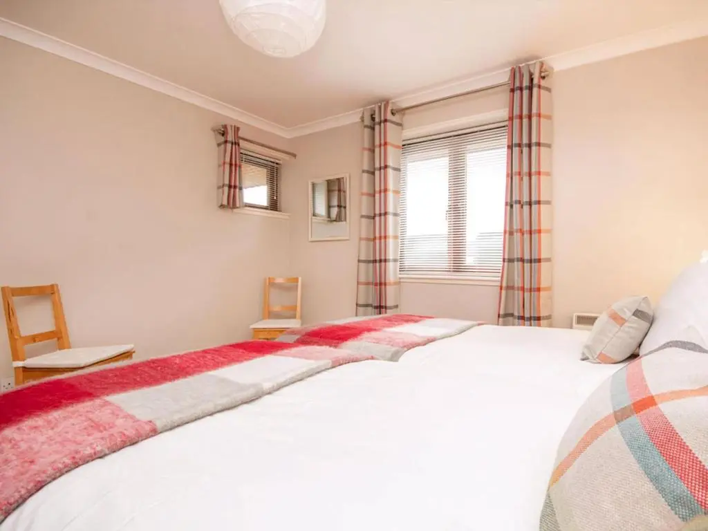 a bedroom with a large white bed and a window at Strathy in Dornoch