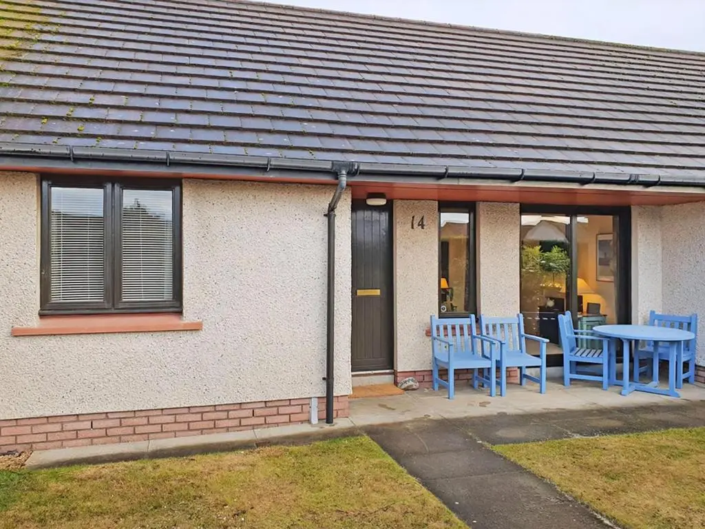 a house with blue tables and chairs on the porch at Strathy in Dornoch