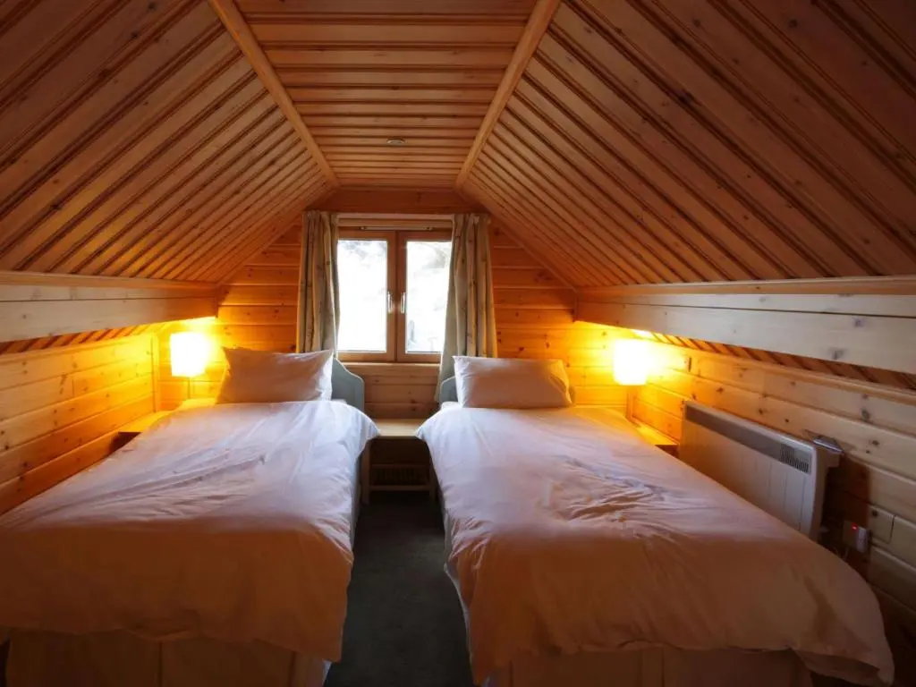 a bedroom with two beds in a wooden house at Taigh Fiodha in Balintore