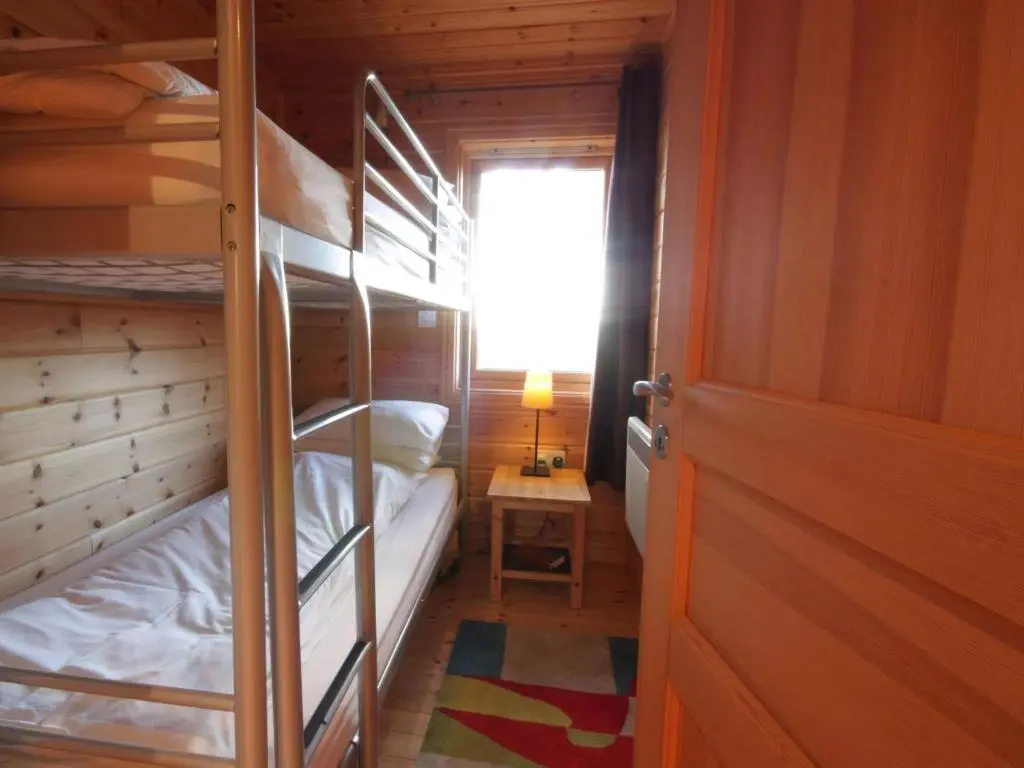 a room with bunk beds and a window and a door at Taigh Fiodha in Balintore