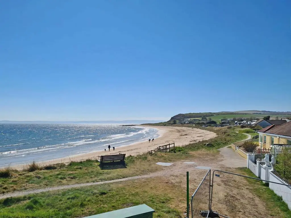 a view of a beach with people walking on it at On The Beach-Uk7465 in Balintore