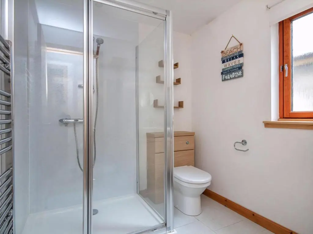 a glass shower in a bathroom with a toilet at The Hive in Dornoch
