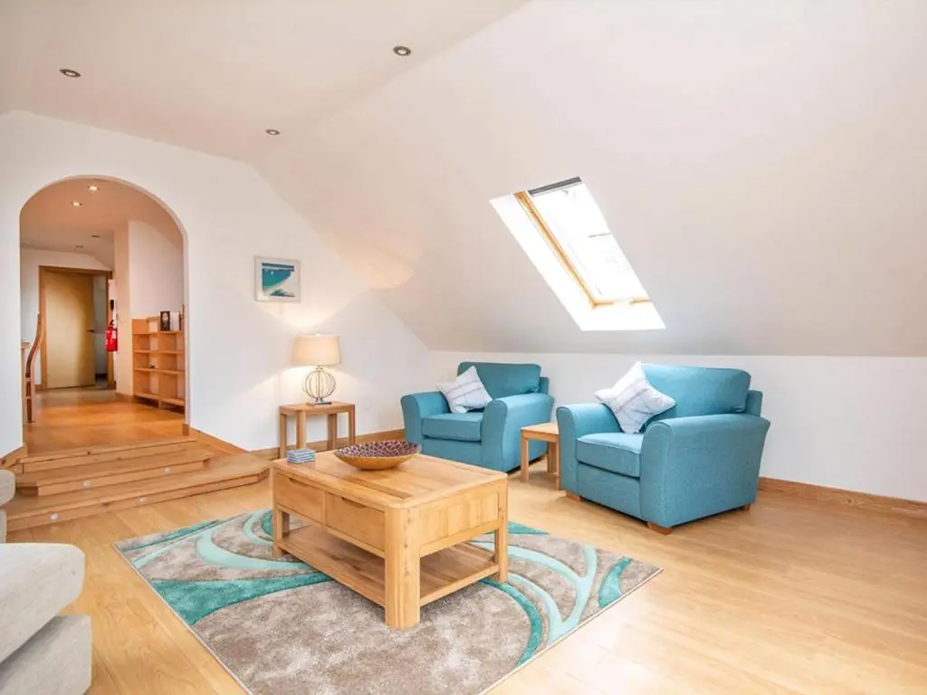 a living room with two blue chairs and a table at The Hive in Dornoch