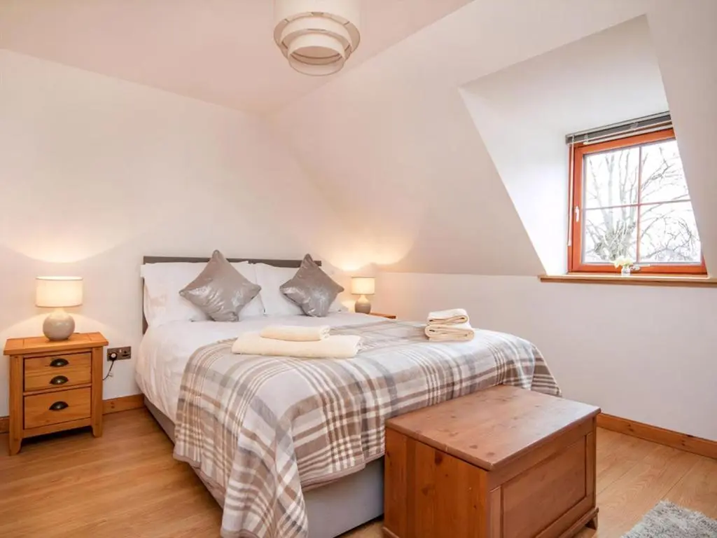 a bedroom with a bed and a wooden table at The Hive in Dornoch