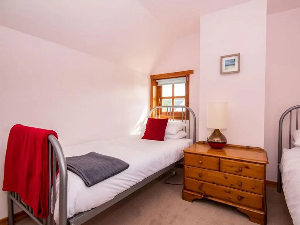 a bedroom with two beds and a dresser and a window at Fernabeg in Edderton