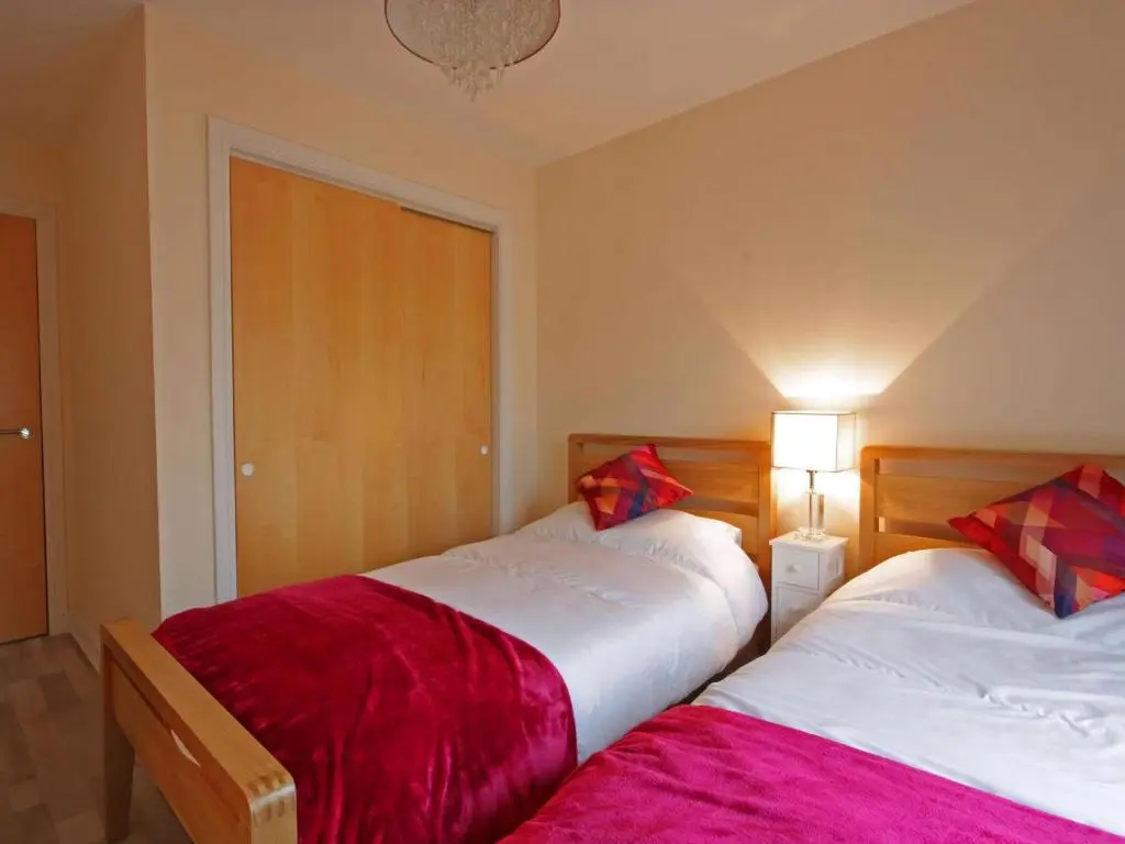 two beds sitting next to each other in a bedroom at Fairway Apartment in Nairn