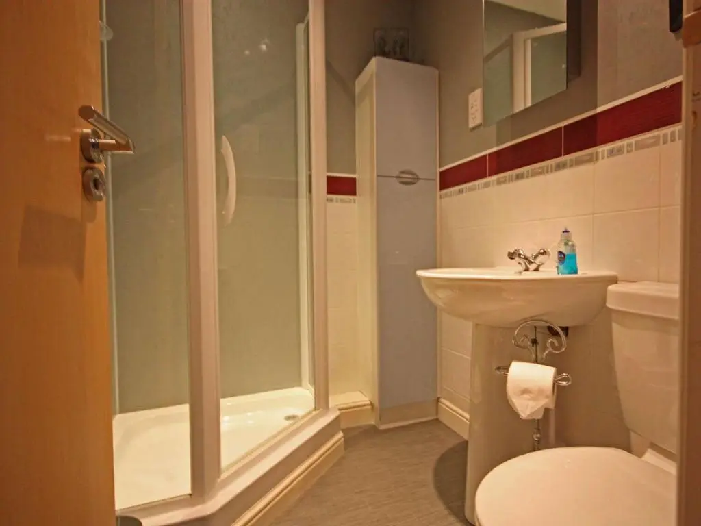 a bathroom with a shower and a toilet and a sink at Fairway Apartment in Nairn