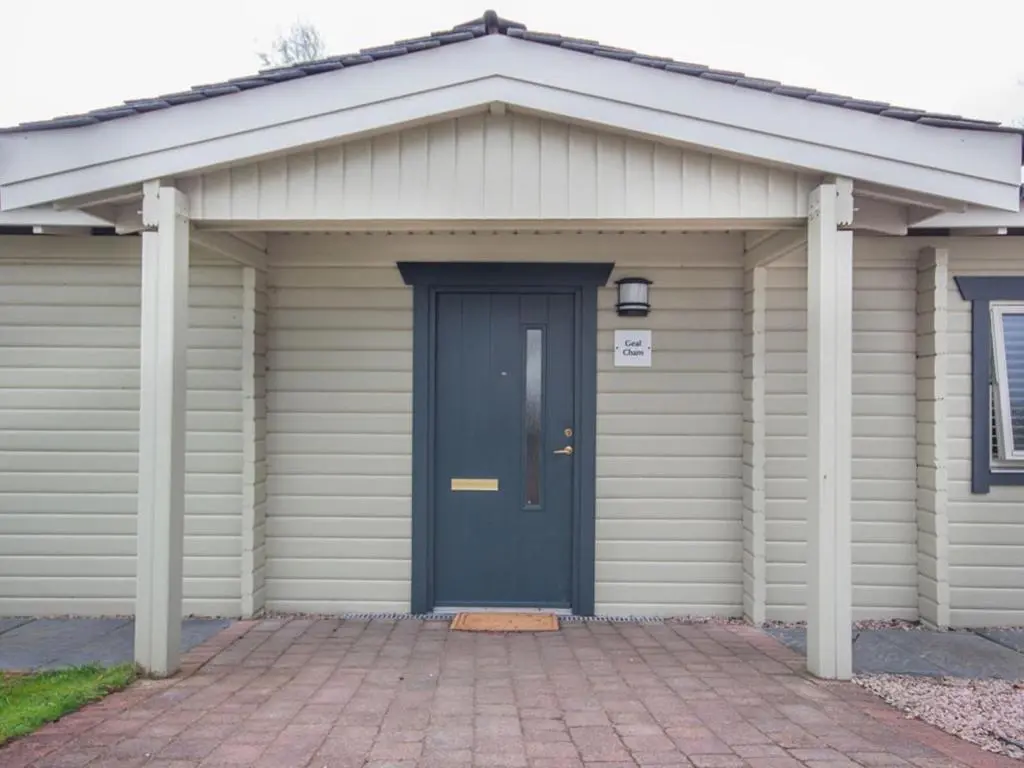 a garage with a blue door and columns at Gael Cham in Aviemore