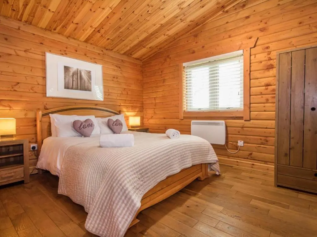 a bedroom with a bed in a wooden cabin at Gael Cham in Aviemore
