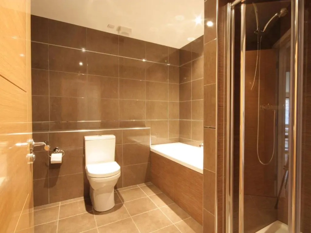 a small bathroom with a toilet and a shower at The Steading Apartment, No9 in Aviemore
