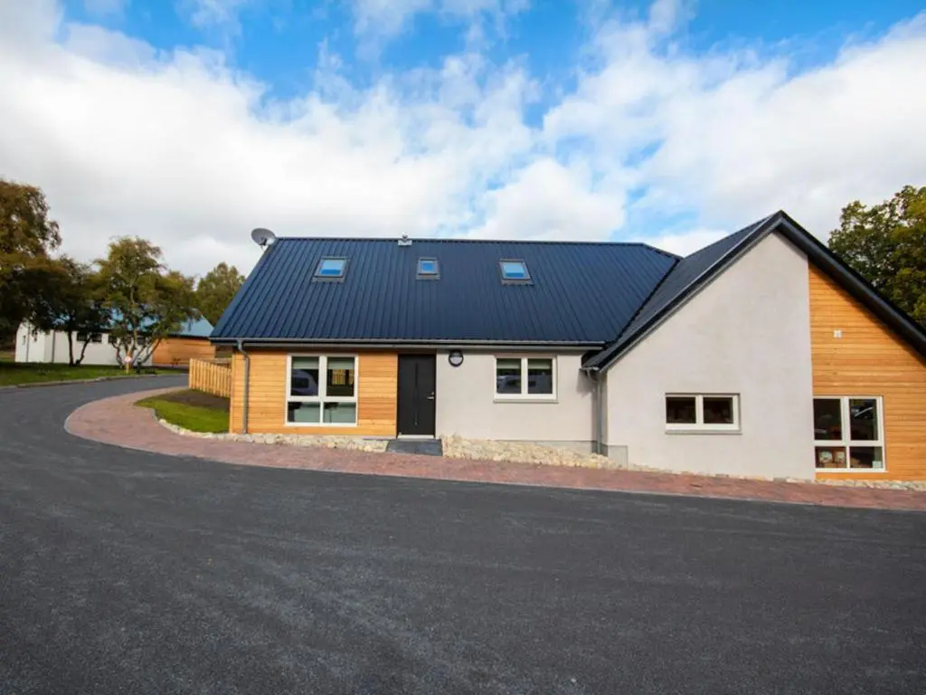 a house with a solar roof on a road at Oakwood in Aviemore