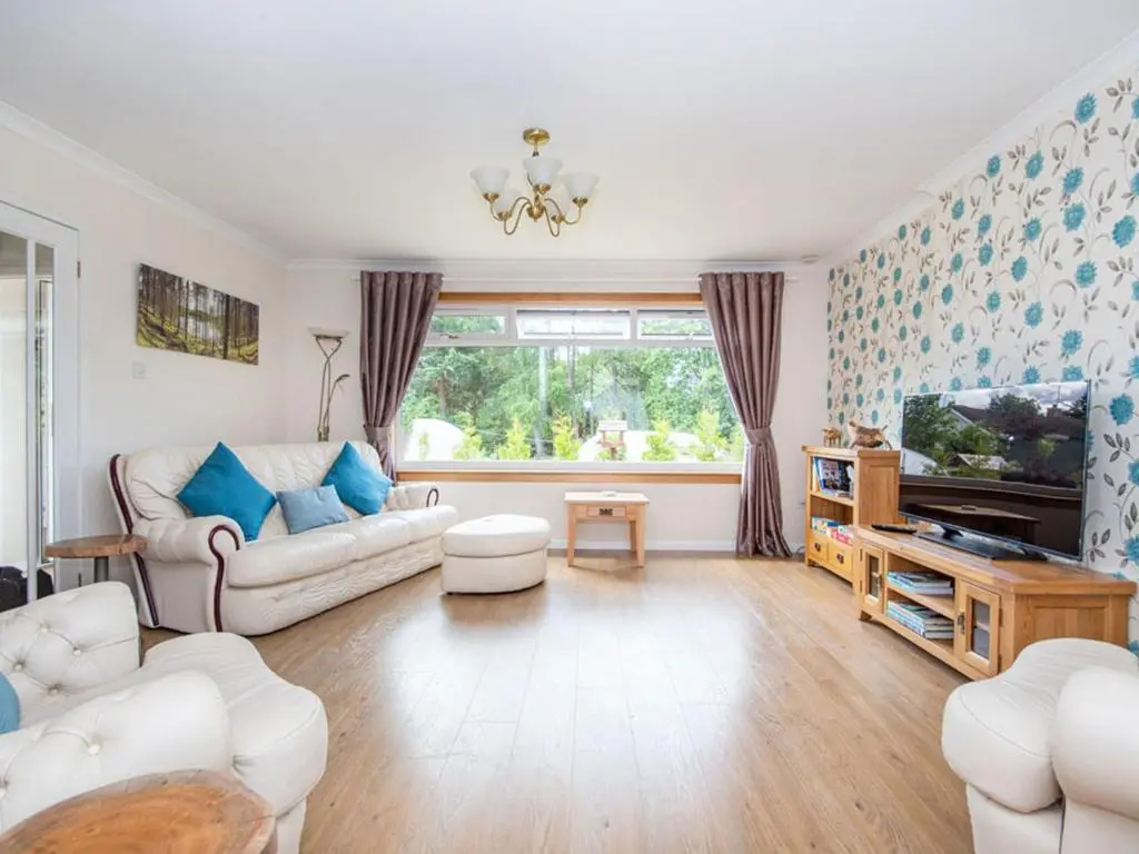 a living room with a couch and a tv at Caledon in Aviemore