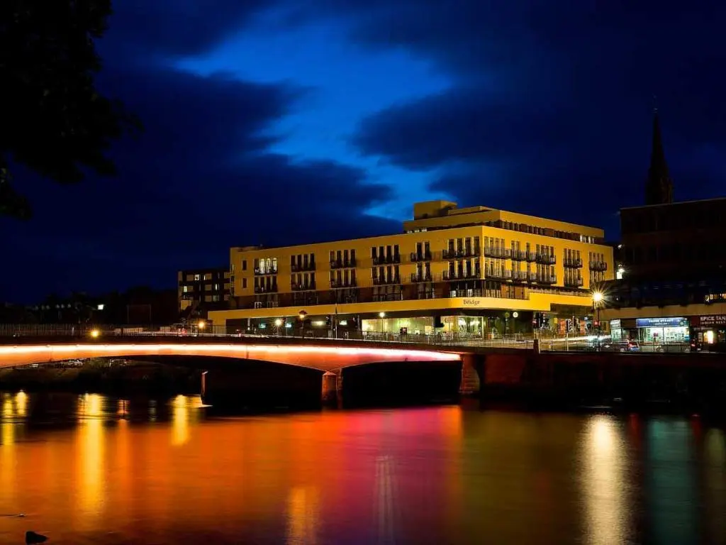 a bridge over a river in a city at night at 208 By The Bridge Apartment in Inverness
