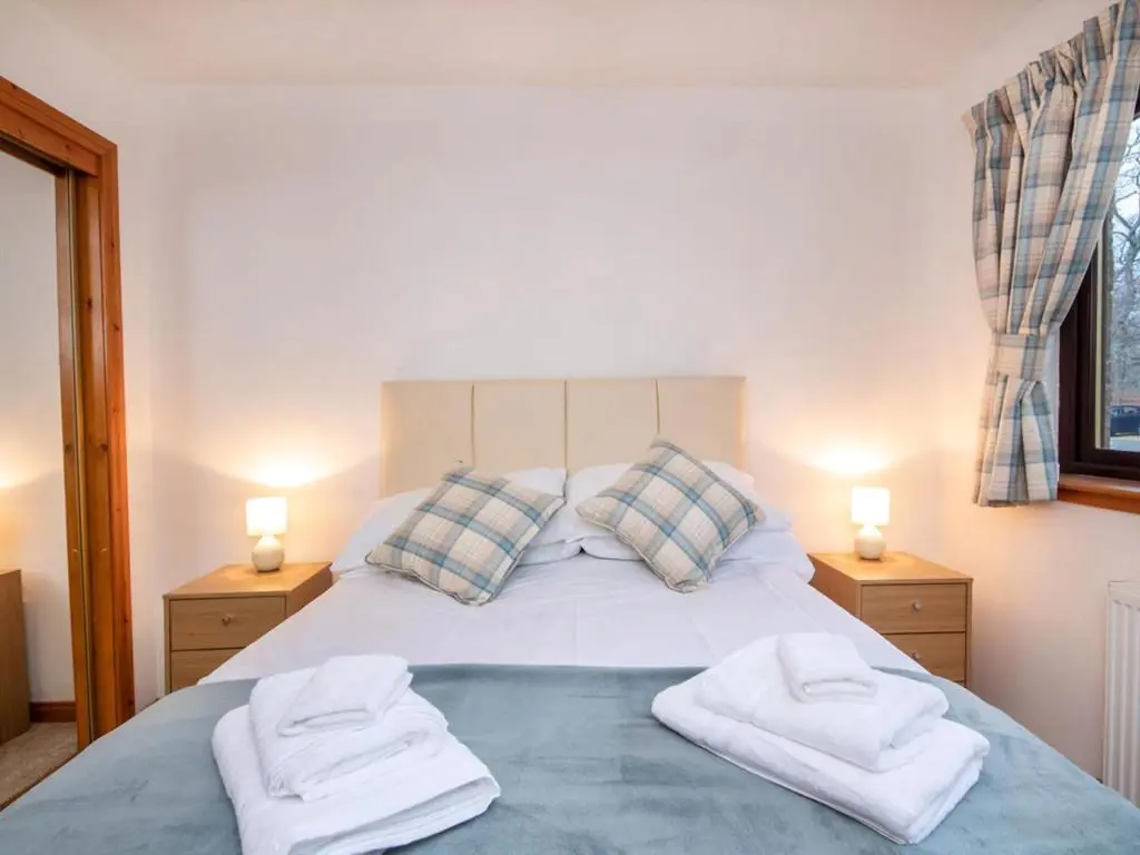 a bedroom with a bed with two towels on it at Holm Dell Apartment in Inshes