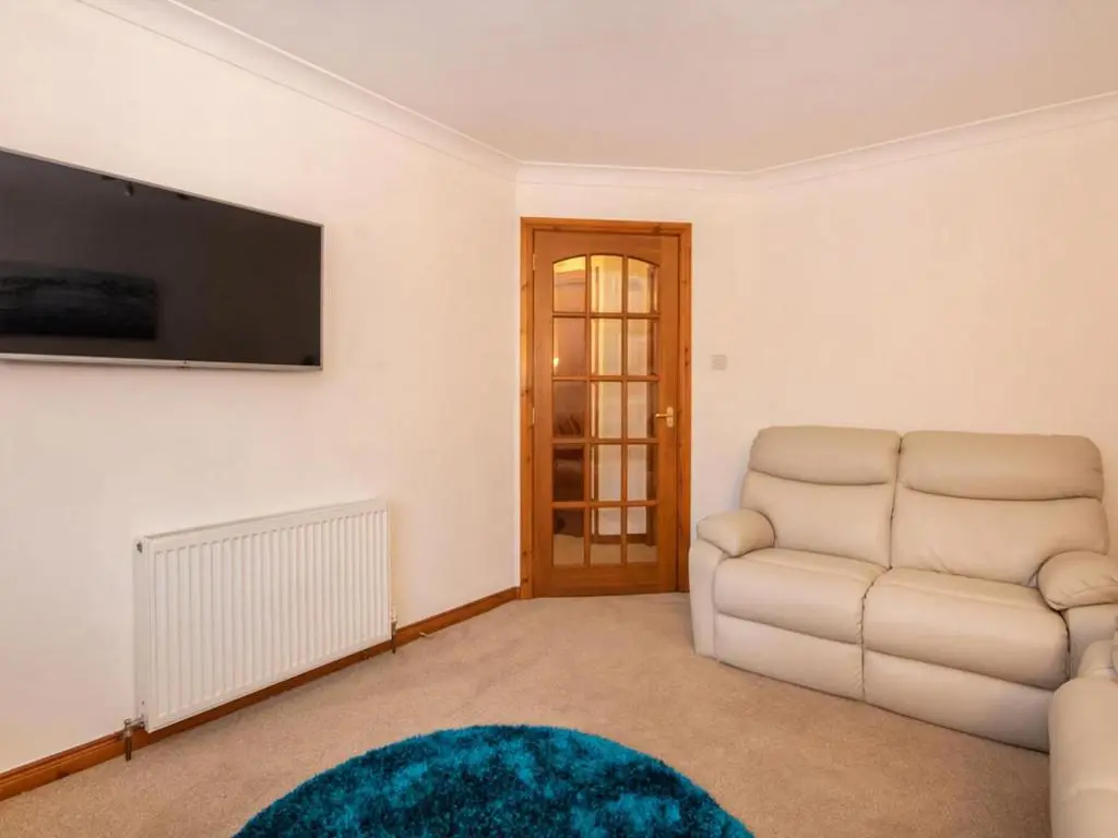 a living room with a couch and a television at Holm Dell Apartment in Inshes