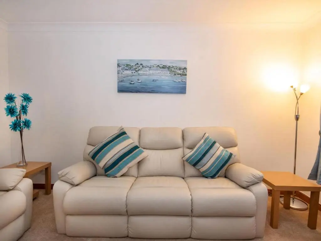 a living room with a couch and a painting on the wall at Holm Dell Apartment in Inshes