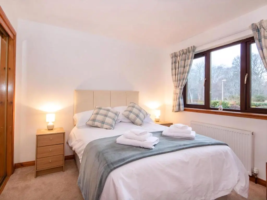 a bedroom with a bed with two towels on it at Holm Dell Apartment in Inshes