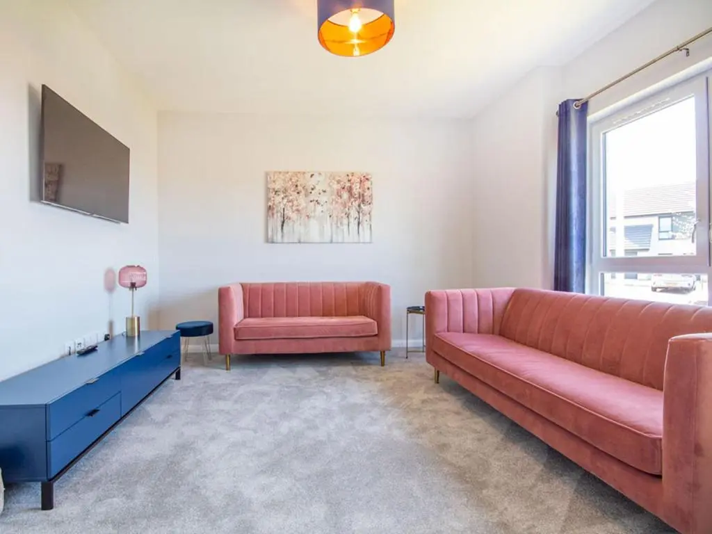 a living room with a couch and a chair at Kessock View Apartment in Inshes