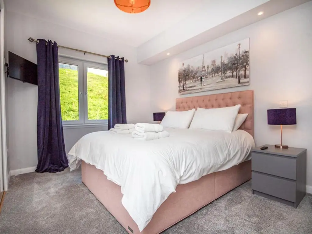 a bedroom with a large bed and a window at Kessock View Apartment in Inshes