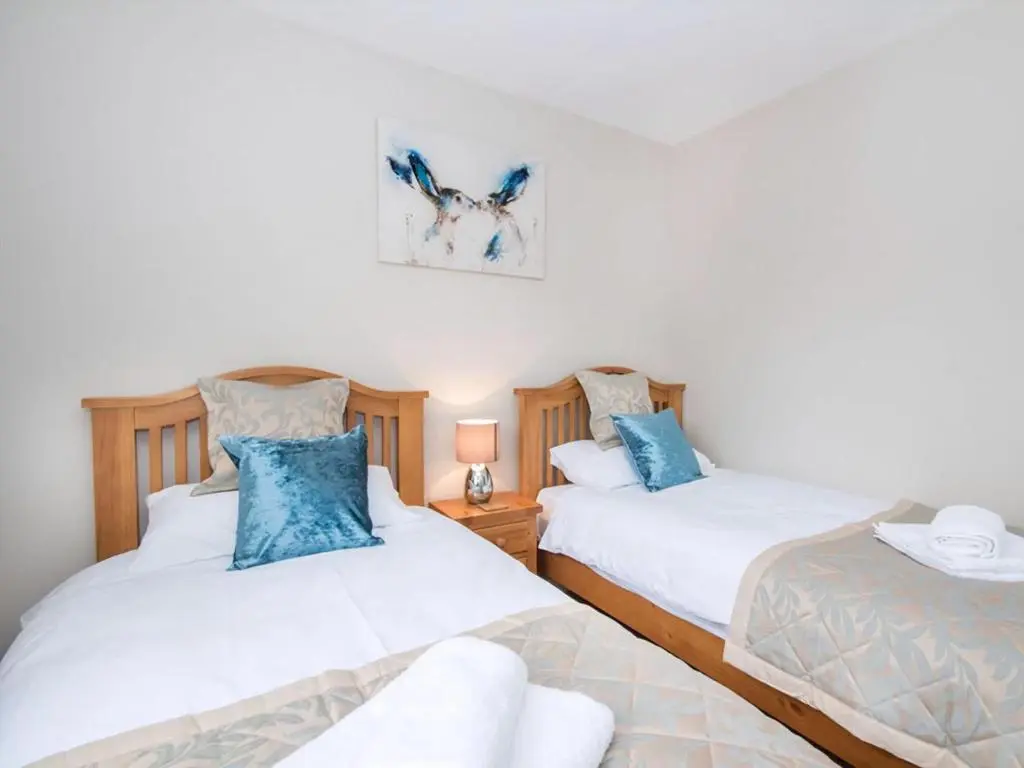 a bedroom with two beds with blue pillows at 58 Moray Park in Culloden