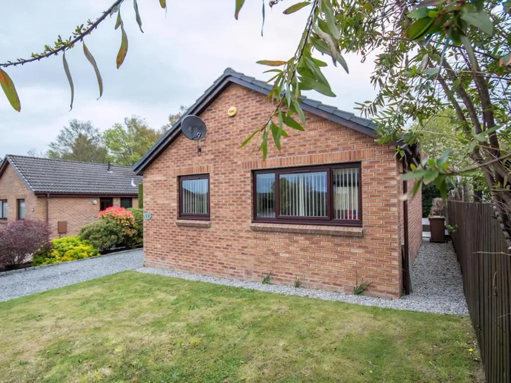 a brick house with a yard at 58 Moray Park in Culloden