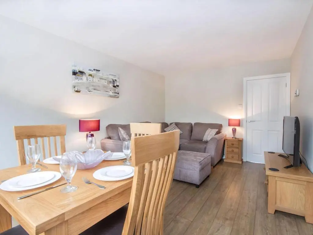 a living room with a table and a couch at 58 Moray Park in Culloden
