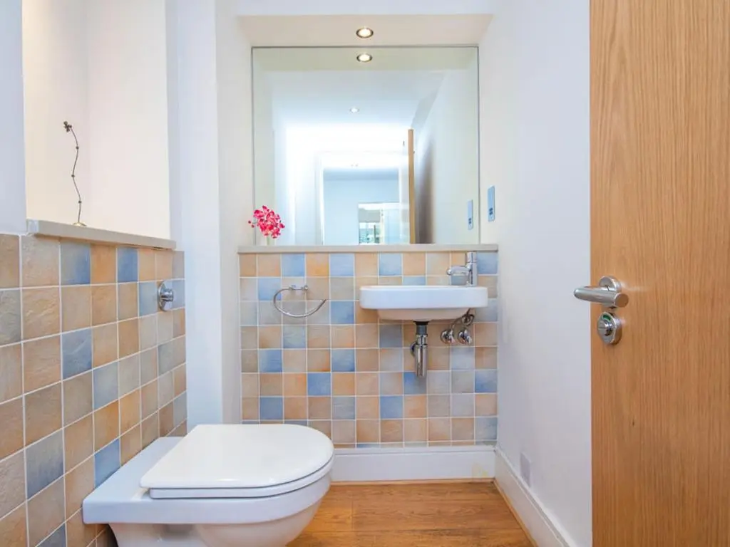 a bathroom with a toilet and a sink and a mirror at 206 By The Bridge Apartment in Inverness