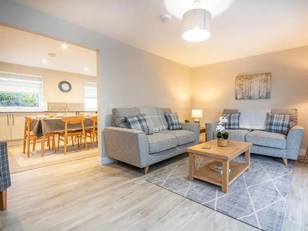 a living room with two couches and a table at Sunnyside Culloden in Inverness