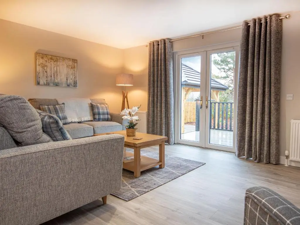 a living room with a couch and a table at Sunnyside Culloden in Inverness