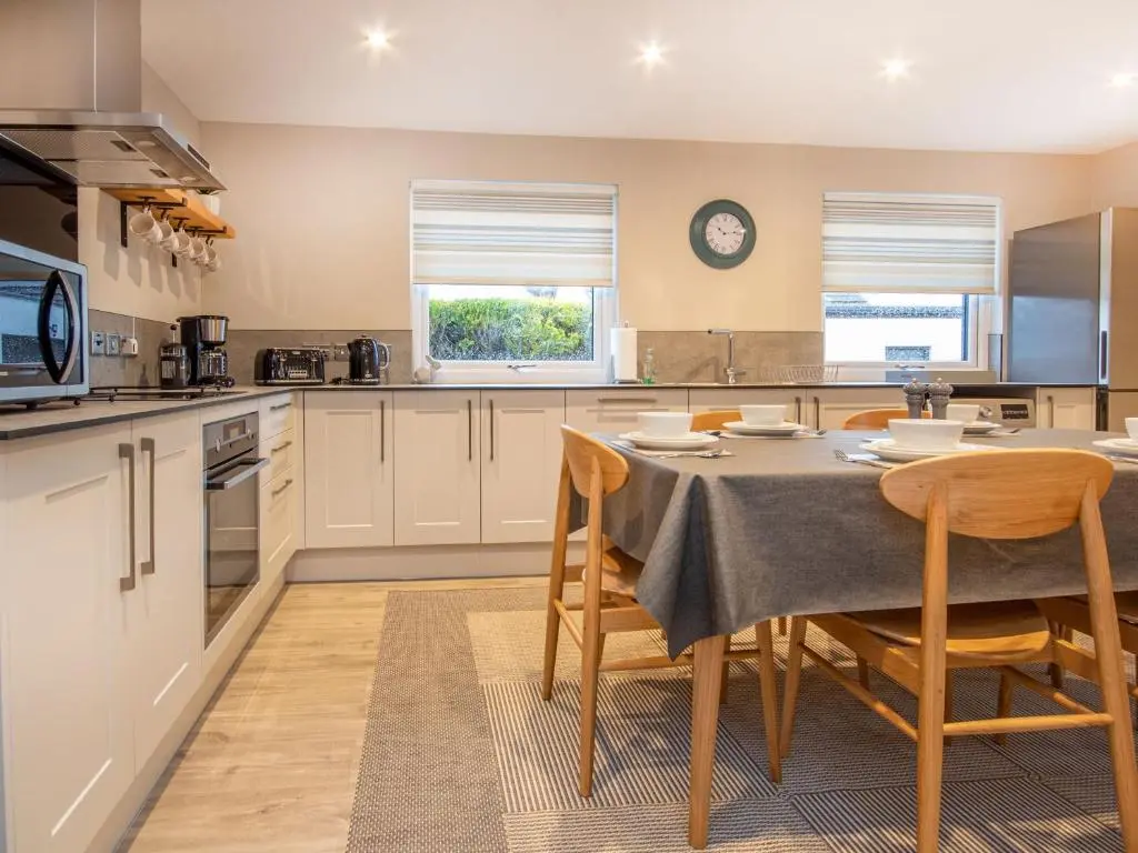 a kitchen with a table and chairs in a room at Sunnyside Culloden in Inverness
