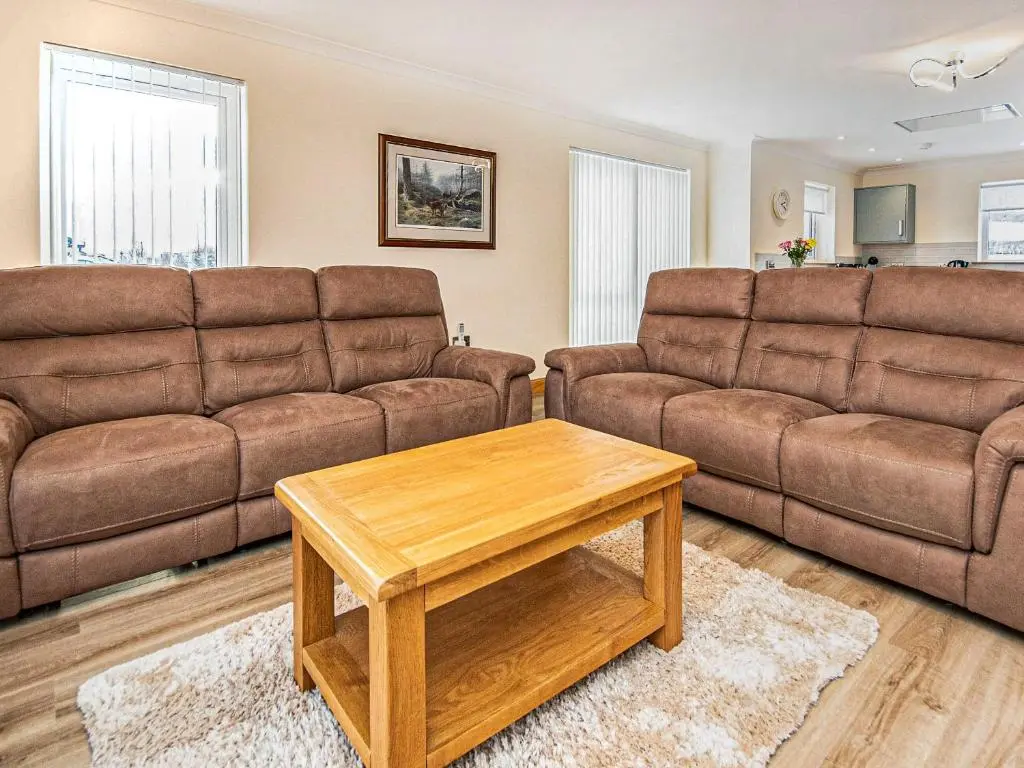 a living room with two brown couches and a coffee table at Terra Verde in Beauly
