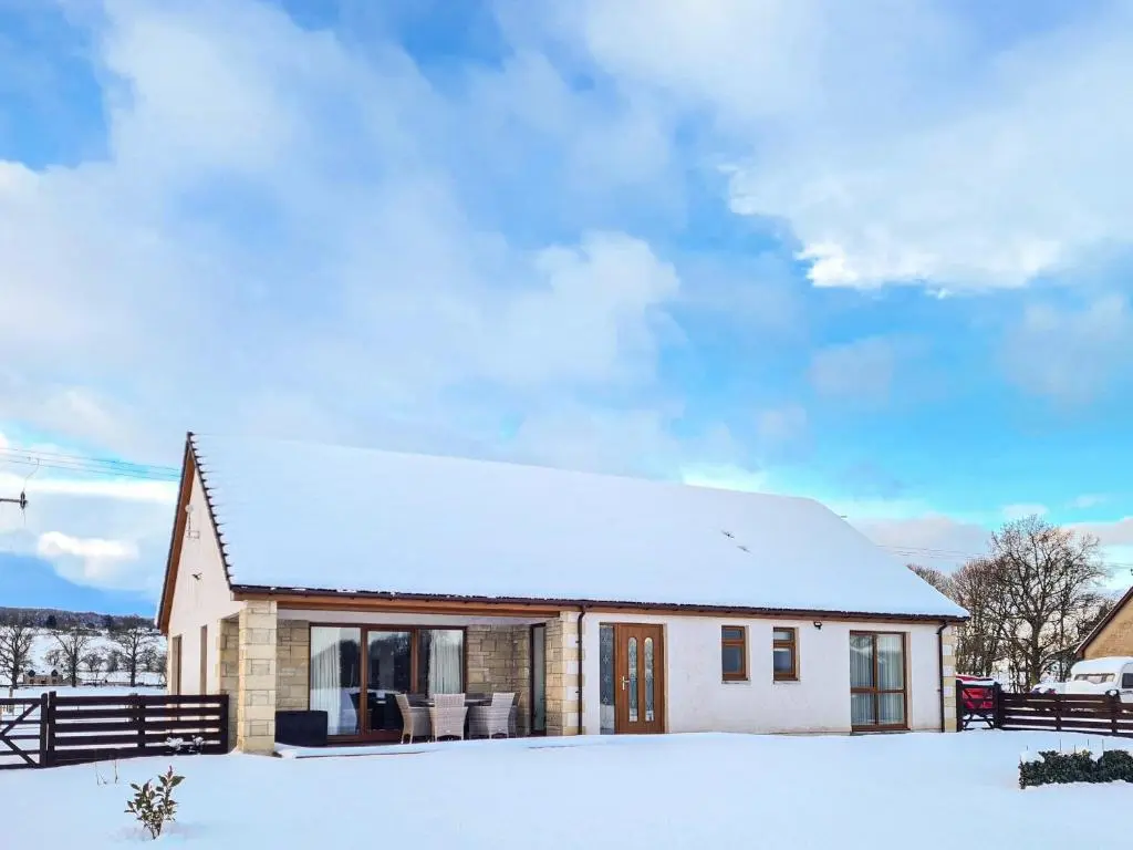 a small white house with snow on the ground at Terra Verde in Beauly