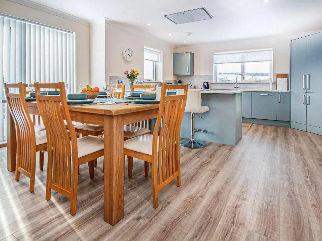 a kitchen and dining room with a wooden table and chairs at Terra Verde in Beauly