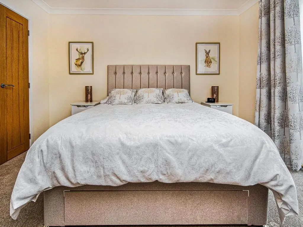 a bedroom with a large bed with white sheets and pillows at Terra Verde in Beauly