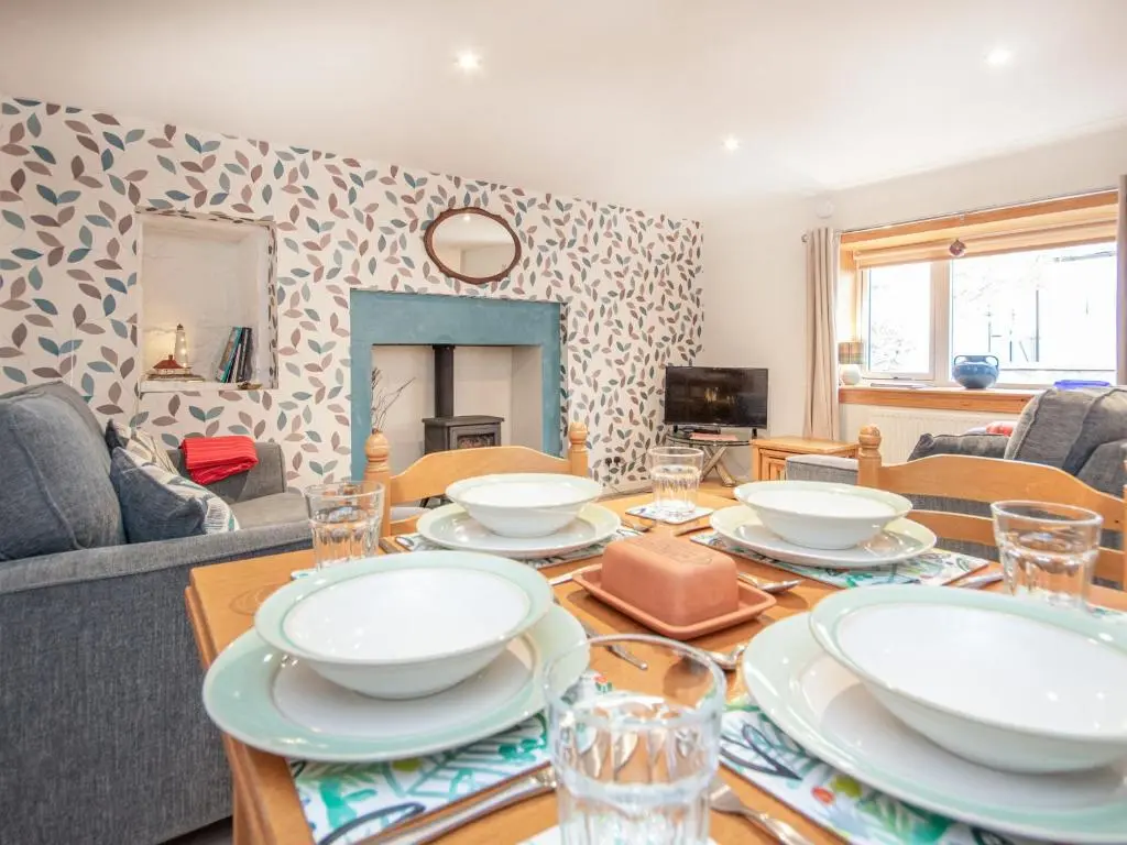 a living room with a table with plates on it at Isla's Cottage in Nairn