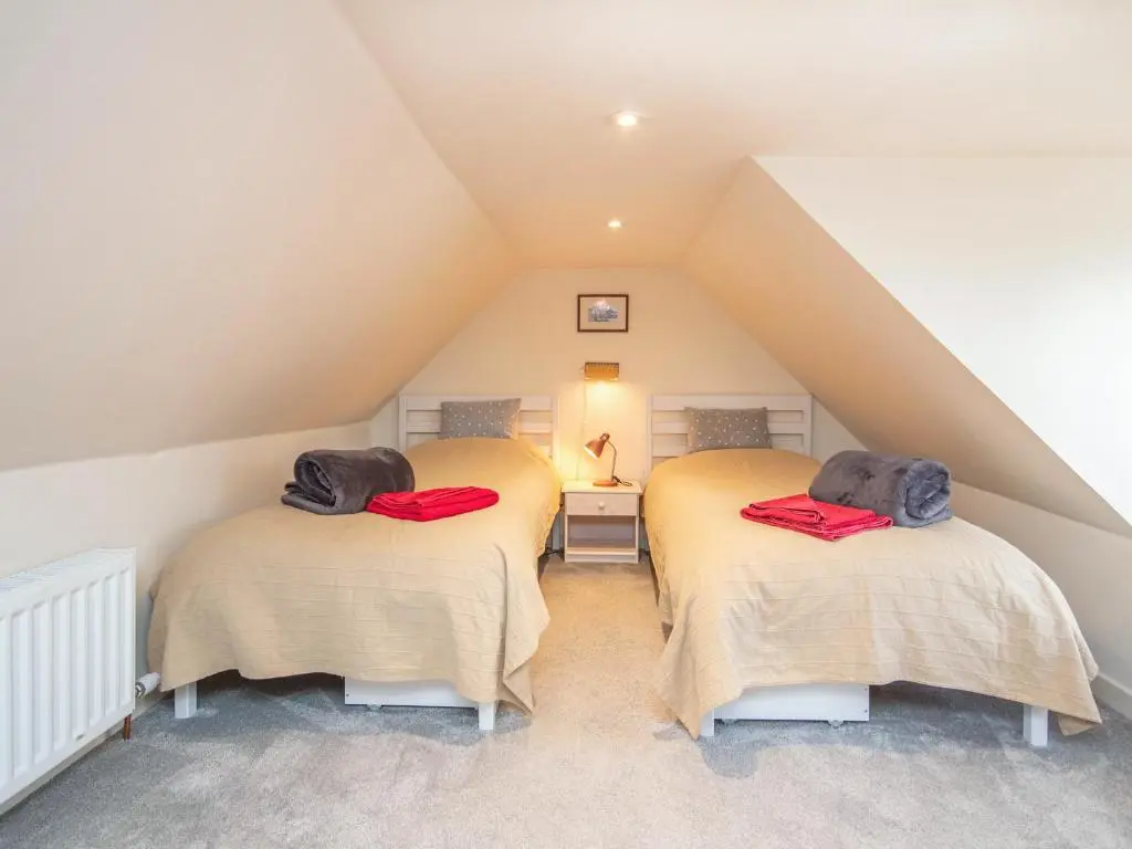two twin beds in a attic room with at Isla's Cottage in Nairn