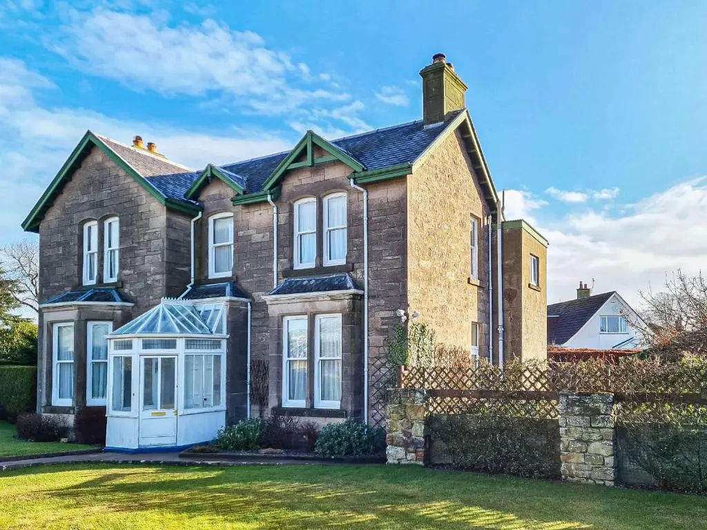 a large brick house with white windows at Reay House in Nairn