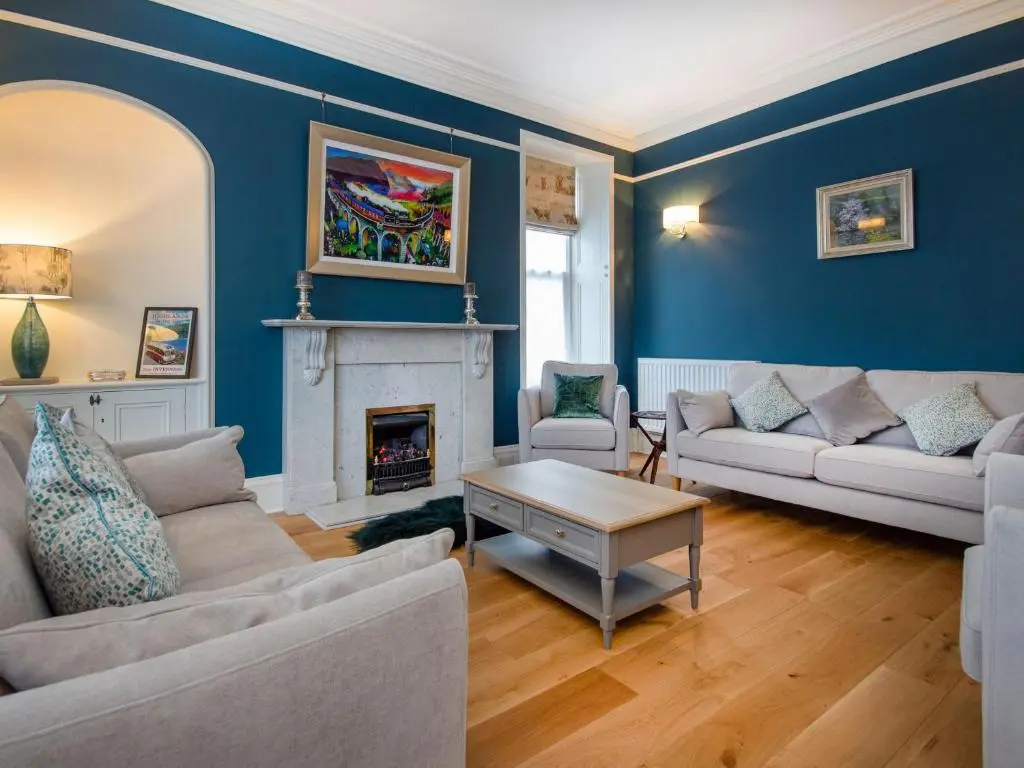 a living room with two couches and a fireplace at Reay House in Nairn
