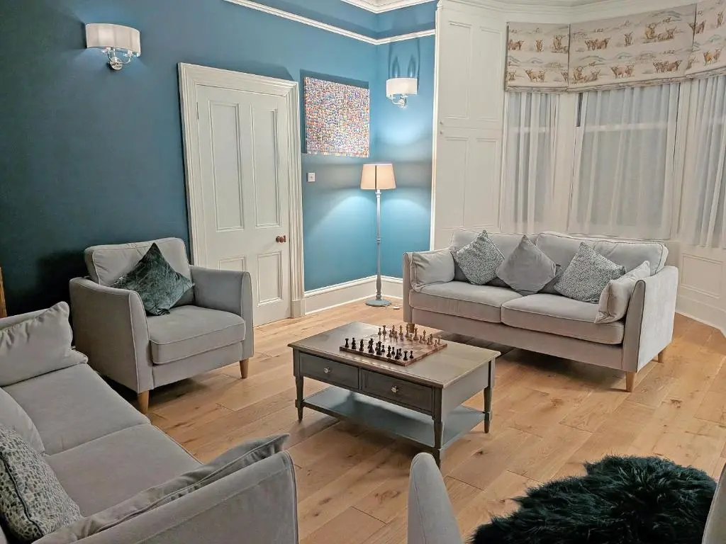 a living room with two couches and a chessboard on a table at Reay House in Nairn