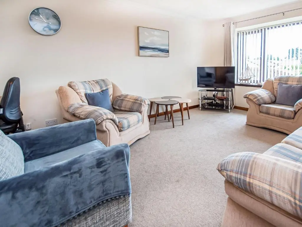 a living room with several couches and a tv at Bow Fiddle in Nairn