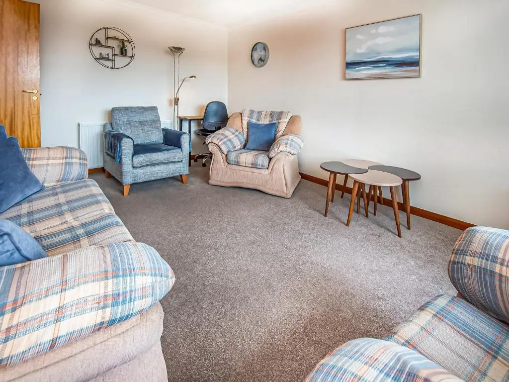 a living room with two couches and a table and chairs at Bow Fiddle in Nairn