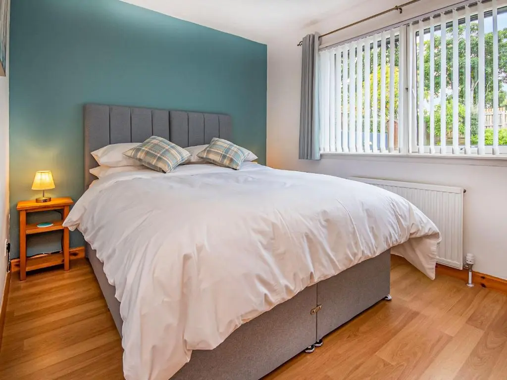 a bedroom with a large bed and a window at Bow Fiddle in Nairn