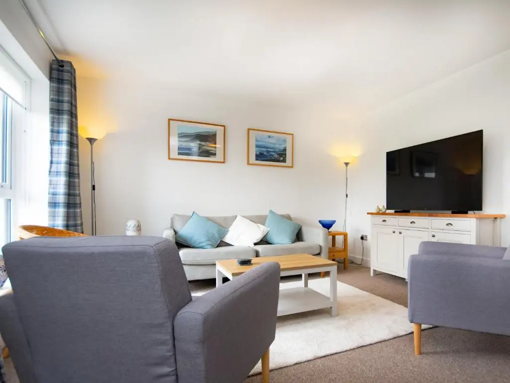 a living room with a couch and a tv at Thistledown in Dornoch