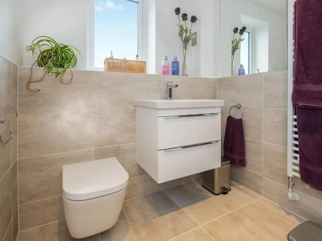a bathroom with a white toilet and a sink at Thistledown in Dornoch