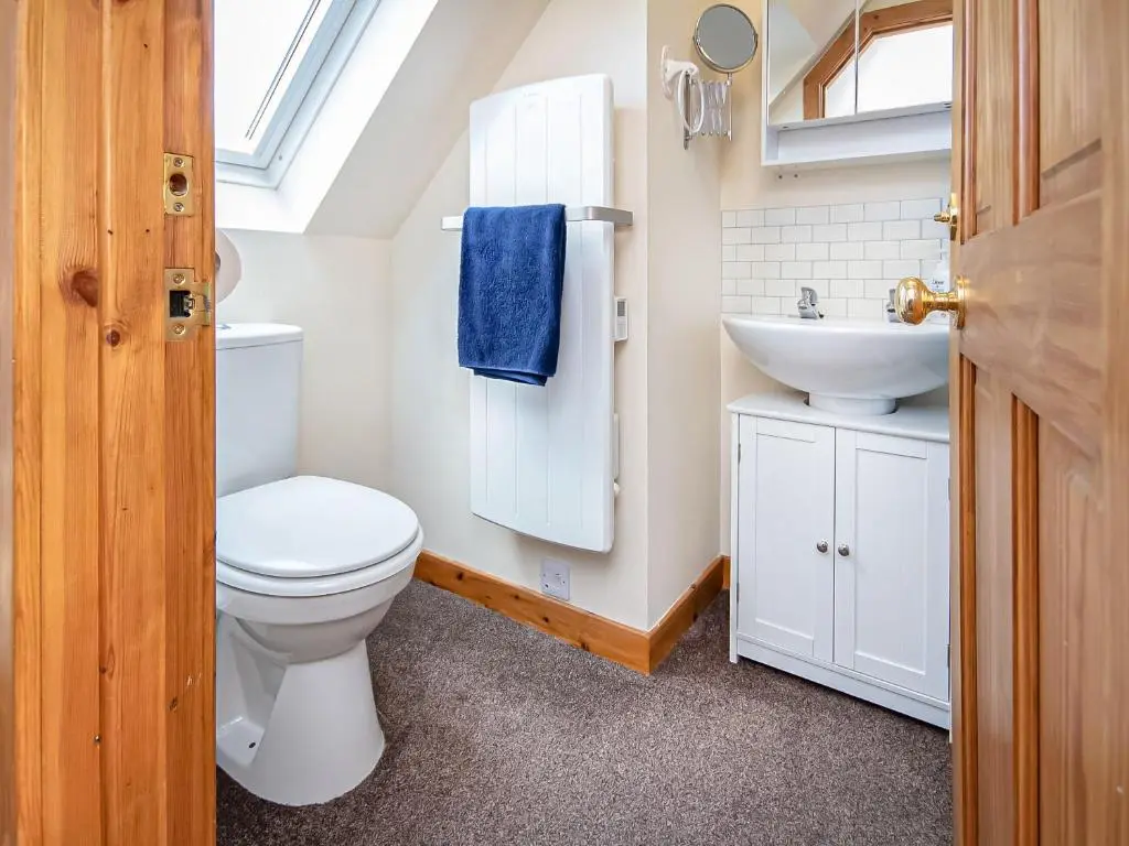 a bathroom with a toilet and a sink at Sunnyside Cottage in Embo